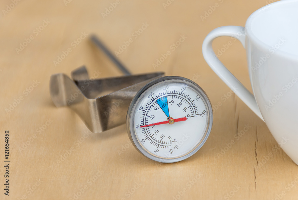 Thermometer hot drinks such as coffee, tea, chocolate and milk. Placed beside the white glass. Thermometer hot drinks such as coffee, tea, chocolate and milk. Placed beside the white glass.