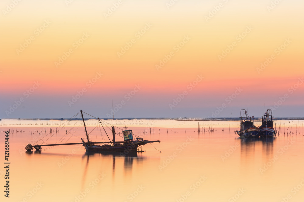 fishing boat used as a vehicle for finding fish in the sea.at sunset