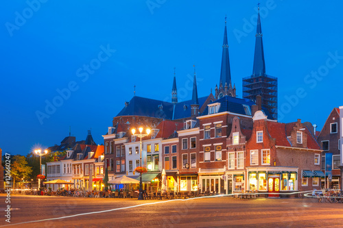 Typical Dutch houses on the Markt square in the center of the old city at night, and Maria van Jessekerk on the background, Delft, Holland, Netherlands