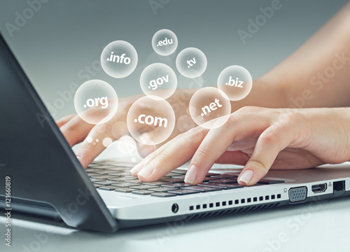 Photography female hand typing on laptop, internet extensions flying