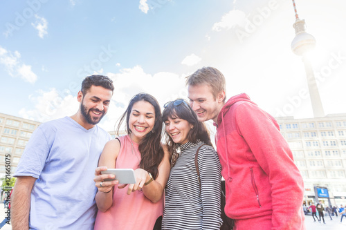 Photography Group of friends looking at smart phone in Berlin