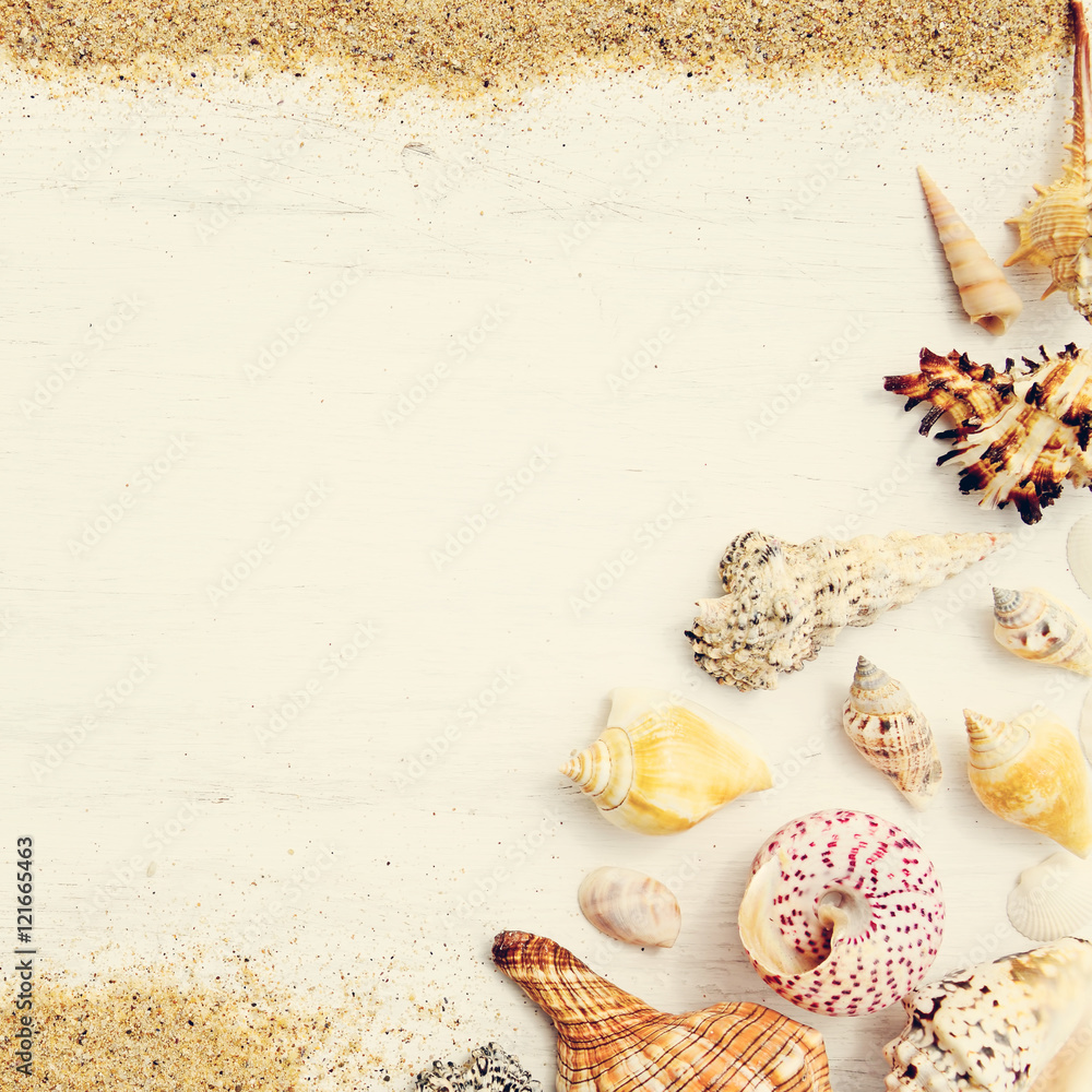 Beach sand, sea shells and starfish on a white wooden background. Photo in vintage style