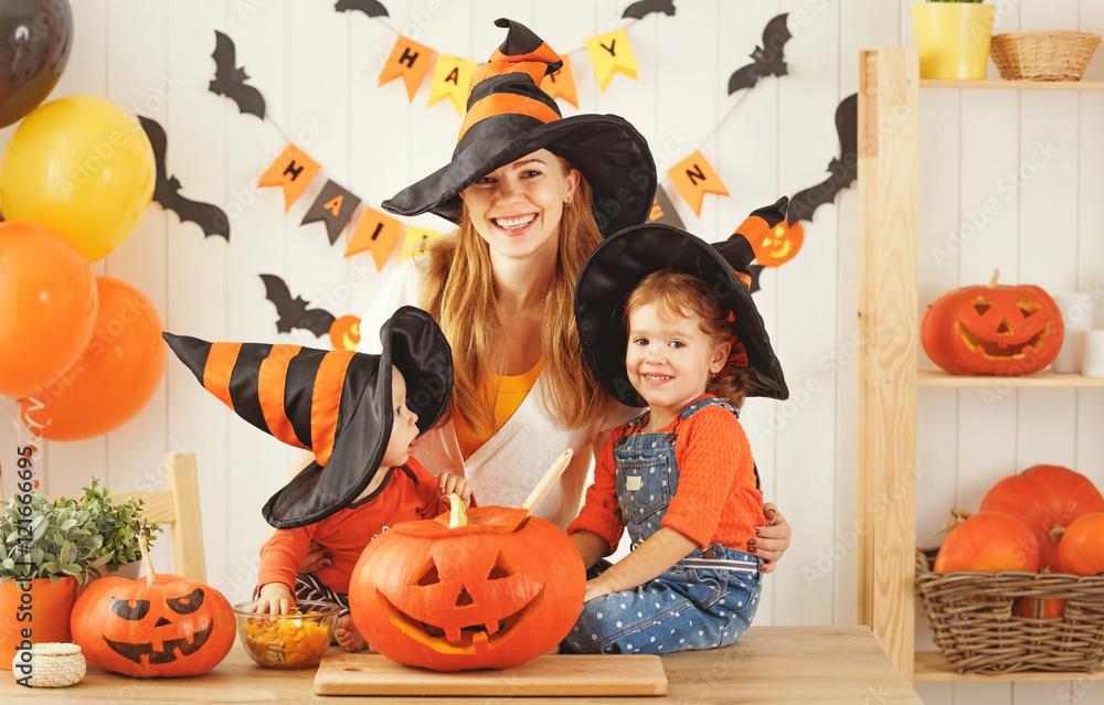 Φωτογραφία Happy family of mother and children prepare for Halloween pumpki