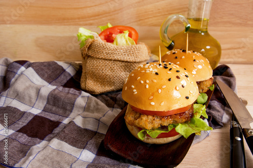 Delicious hot hamburger served with tomato sauce on wooden planks with knife and frok on woodend background photo