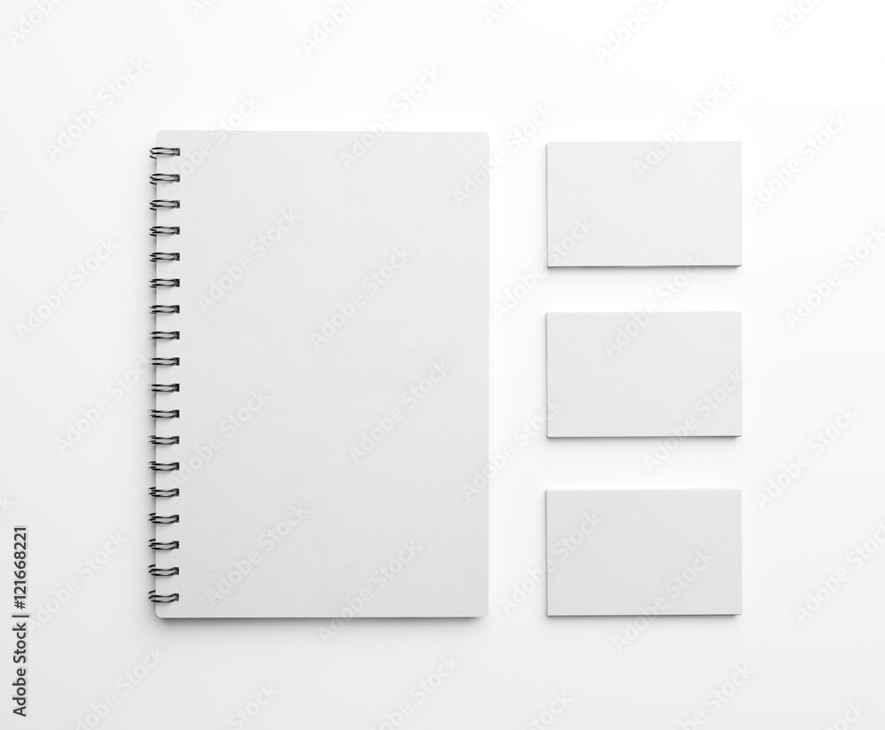 White paper notebook and stack of business cards over white background. Top view. 3d rendering White paper notebook and stack of business cards over white background. Top view. 3d rendering