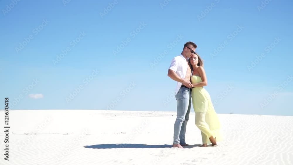 Loving couple embracing in the desert in the wind Loving couple embracing in the desert in the wind