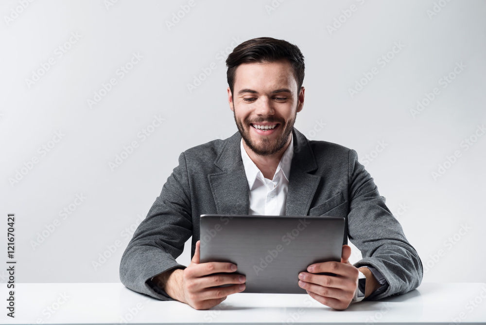 Satisfied bearded man smiling and using laptop. Satisfied bearded man smiling and using laptop.