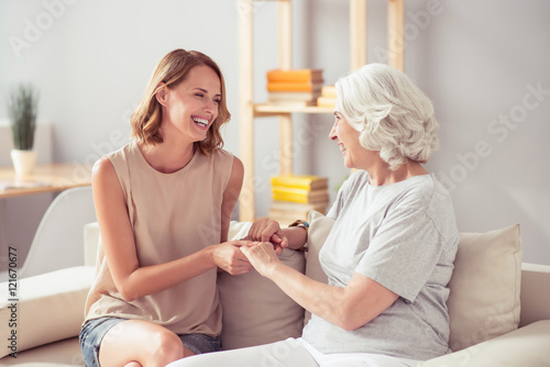 Joyful woman sitting with her grandmother on the sofa