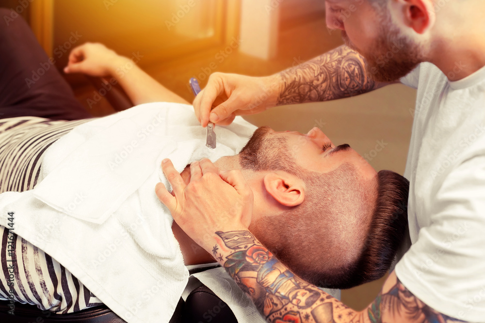 Young man having beard shaven Young man having beard shaven