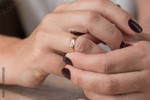 Divorce, separation: woman removing wedding or engagement ring