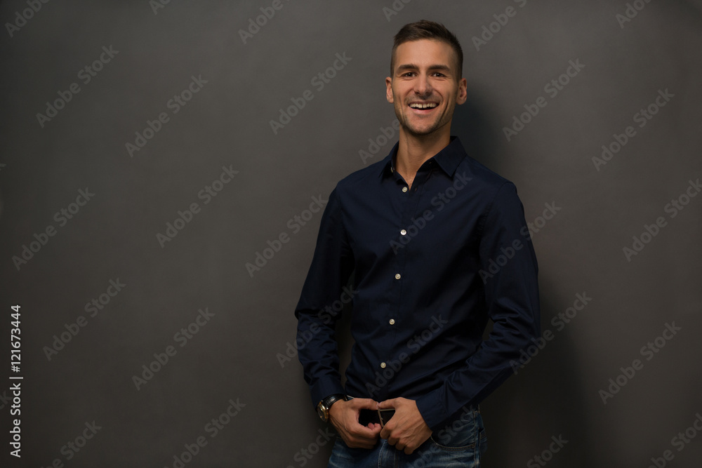 Fototapeta premium Close up picture of happy smiling mans face in studio. Handsome man with short haircut toothy smiling for camera while posing over grey background. Fashion or vogue concept.