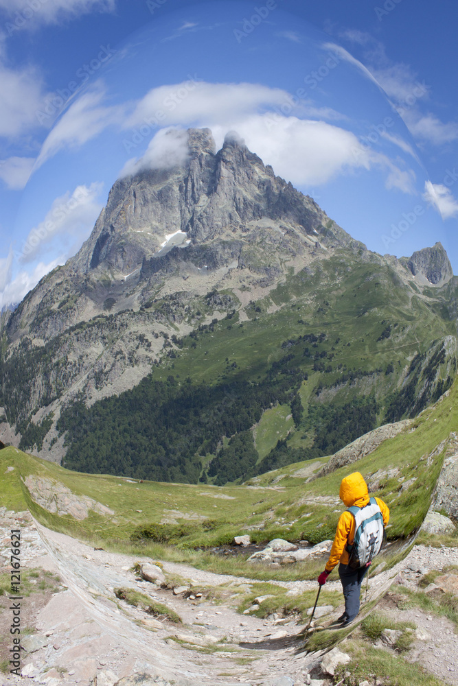 girl hiking with the Midi d'Ossau peak behind in France