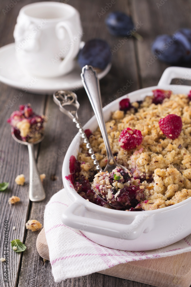 Plum and raspberry crumb on the old wooden background. Rustic style. Selective focus. Plum and raspberry crumb on the old wooden background. Rustic style. Selective focus.