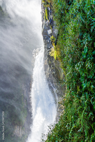 Austrian Alps. Starting famous Krimml waterfalls. Crystal clear water sparkles in the midday sun. Through the narrow creek wooden bridge spanned