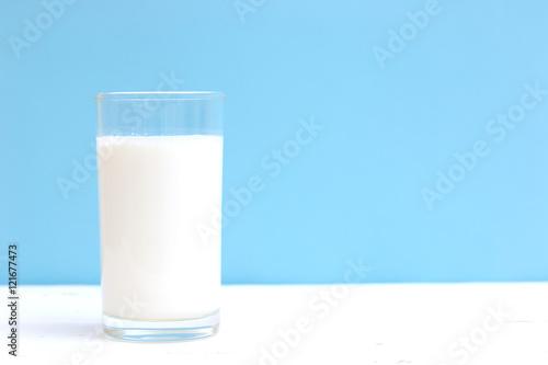 Glass of milk on white wooden table