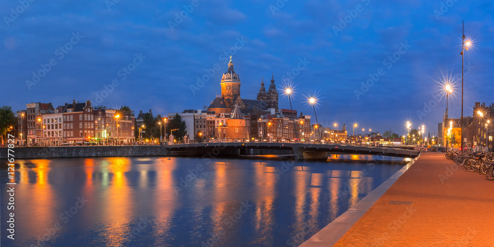 Obraz premium Night panoramic city view of Amsterdam canal, bridge and Basilica of Saint Nicholas, Holland, Netherlands. Long exposure.