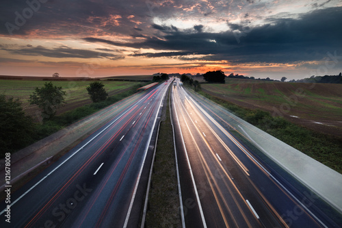 Cars in Motion on Busy Motorway with Colorful Twilight Sky