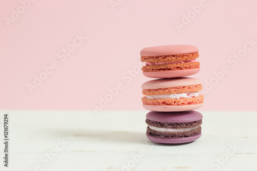 Fototapeta Naklejka Na Ścianę i Meble -  Sweet and colorful french macaroons or macaron on white wooden table pink background, Dessert.