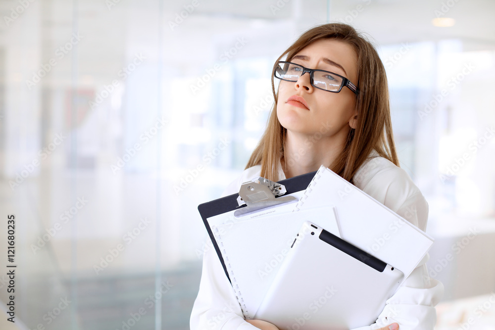 Tired business woman standing in the office