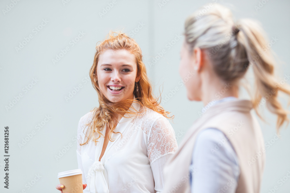 Two women walking in the city and talking. Young businesswomen in London taking a break from office on a sunny day. City and work lifestyle concepts with real people. Two women walking in the city and talking. Young businesswomen in London taking a break from office on a sunny day. City and work lifestyle concepts with real people.