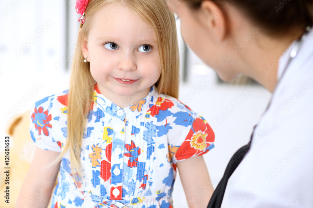 Pediatrician is taking care of baby in hospital. Little girl is being examine by doctor by stethoscope. Health care, insurance and help concept. Pediatrician is taking care of baby in hospital. Little girl is being examine by doctor by stethoscope. Health care, insurance and help concept.