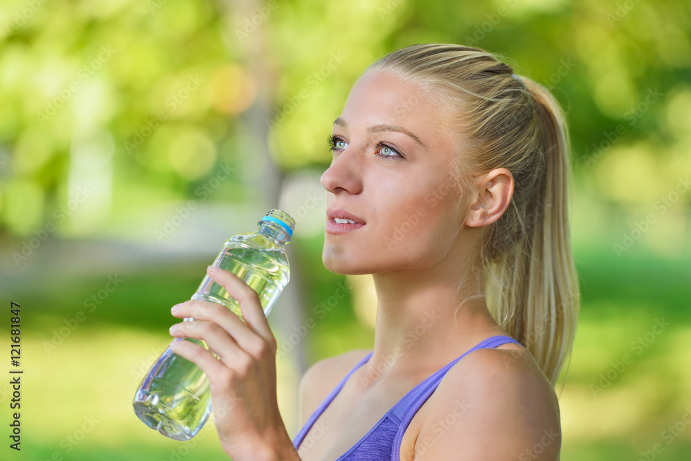 Senior athletic woman drinks water from a bottle after running Senior athletic woman drinks water from a bottle after running
