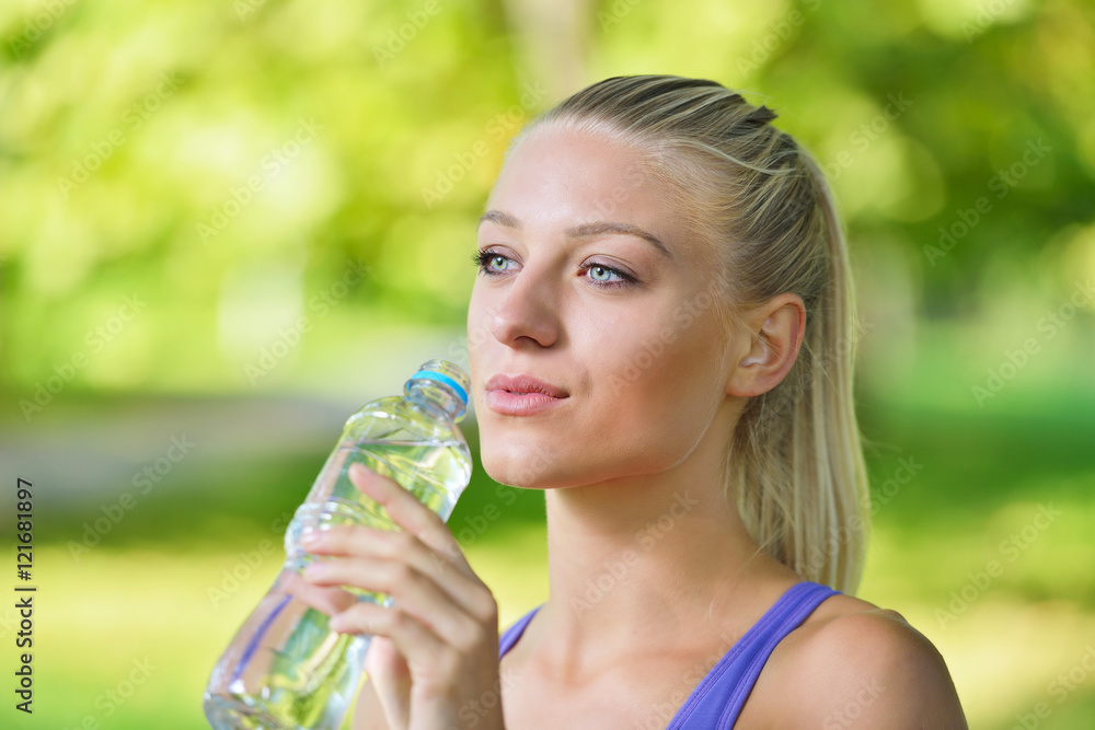 Senior athletic woman drinks water from a bottle after running Senior athletic woman drinks water from a bottle after running