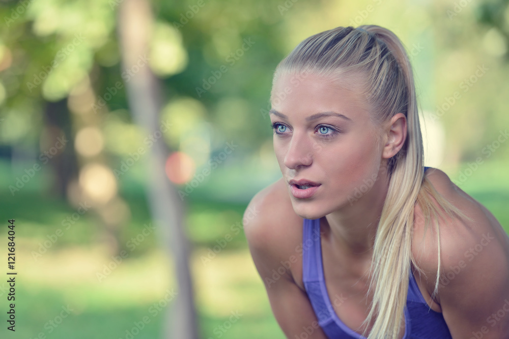 Young woman taking rest after jogging - workout at the park