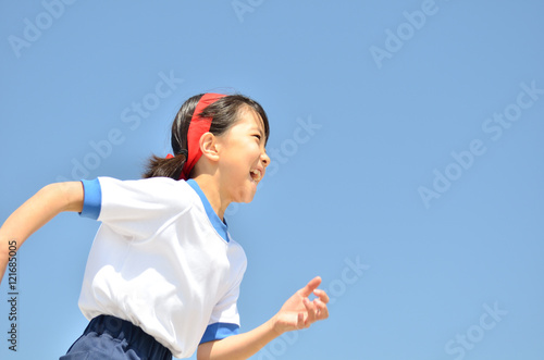 青空で走る女の子（体操服、運動会）