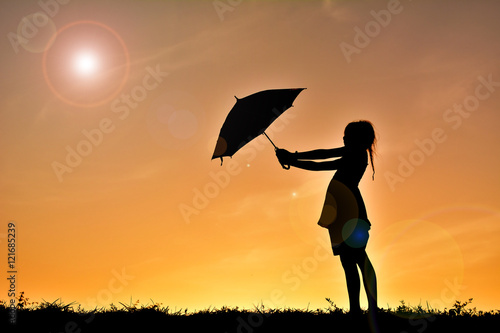 Silhouette girl with umbrella on sunset