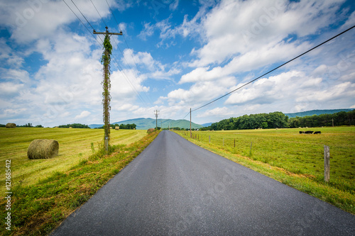 Country road with distant mountains and farm fields in the rural