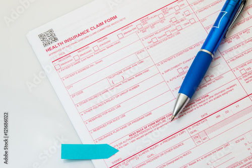 Health insurance claim form with pen on white background.