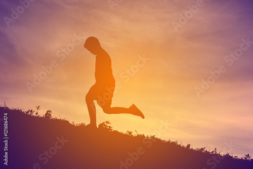 Silhouette a boy running on sunset