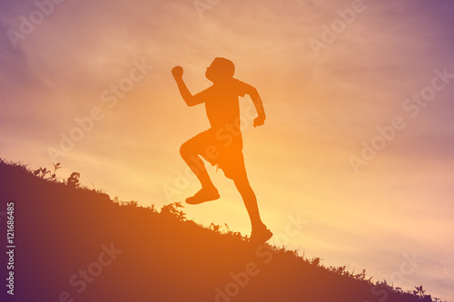 Silhouette a boy running on sunset