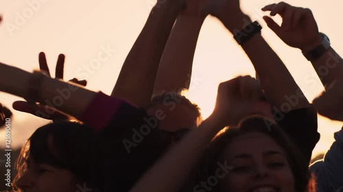 Group of People Dancing and Raising Hands Outdoors in Sunlight. Slow Motion Shot. Shot on RED Cinema Camera in 4K (UHD). photo