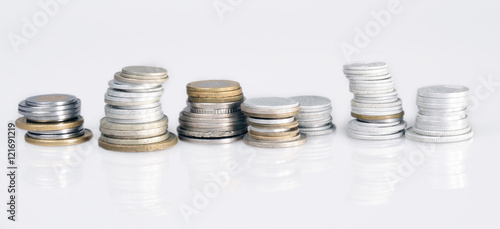  columns of coins from different countries on a white background