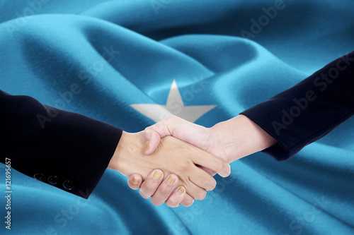 Collaboration handshake with flag of Somalia