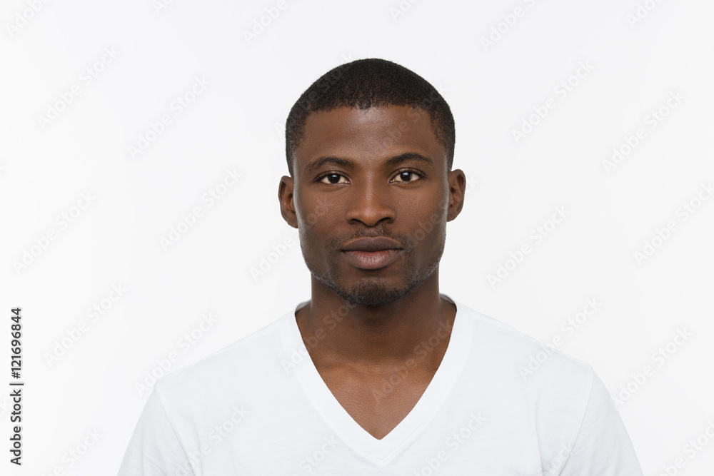 Portrait of handsome African man posing in studio. Short haired man inwhite T-shirt posing isolated on white background. Portrait of handsome African man posing in studio. Short haired man inwhite T-shirt posing isolated on white background.