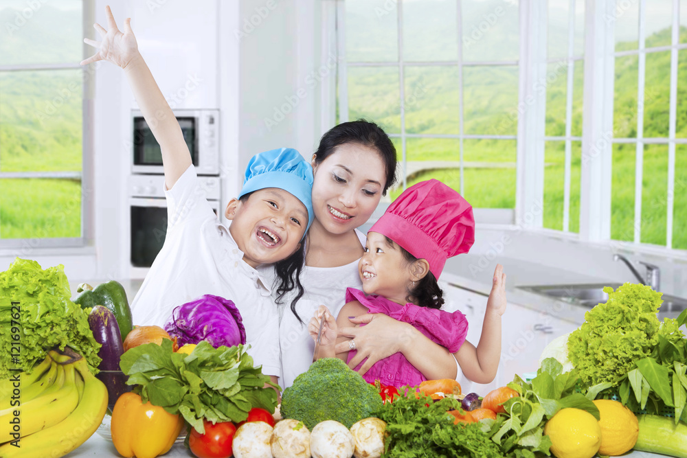 Two kids and their mother cooking vegetables Two kids and their mother cooking vegetables