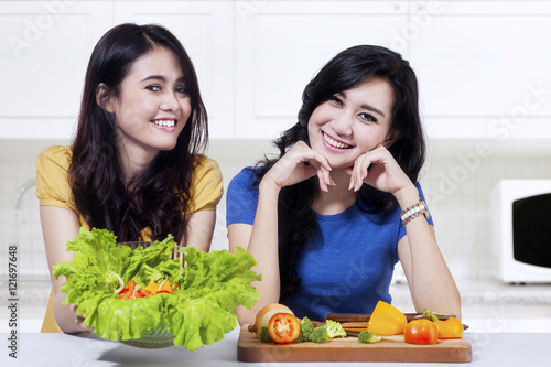 Two woman showing vegetables salad