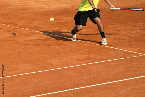 Male tennis player in action on the court on a sunny day © smuki