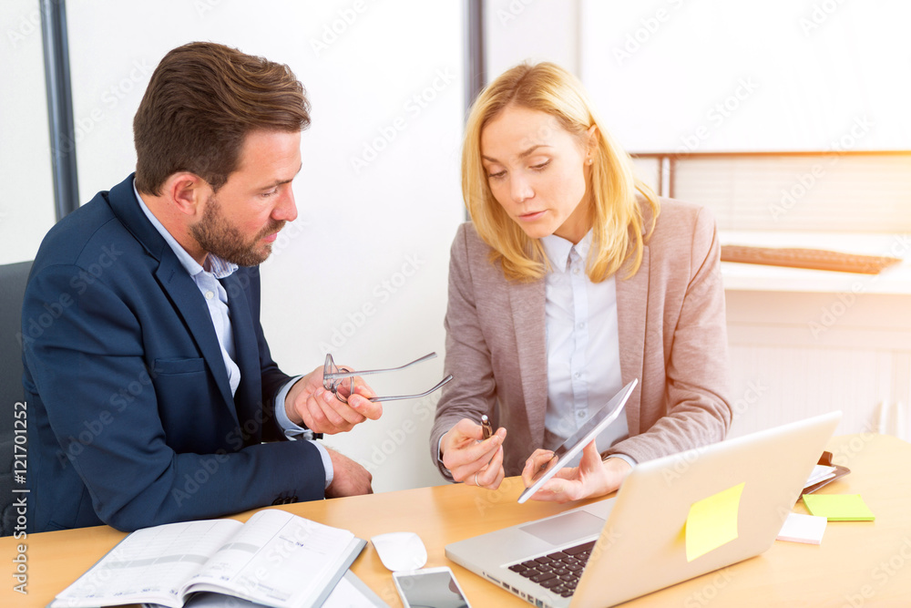 Businessman and his assistant working together at the office Businessman and his assistant working together at the office
