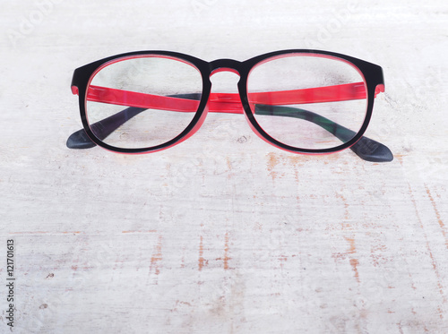 Black and red eye glasses on wood background