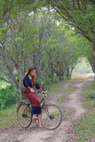 Young asian women sit on an old bike in rice field area.lonely c
