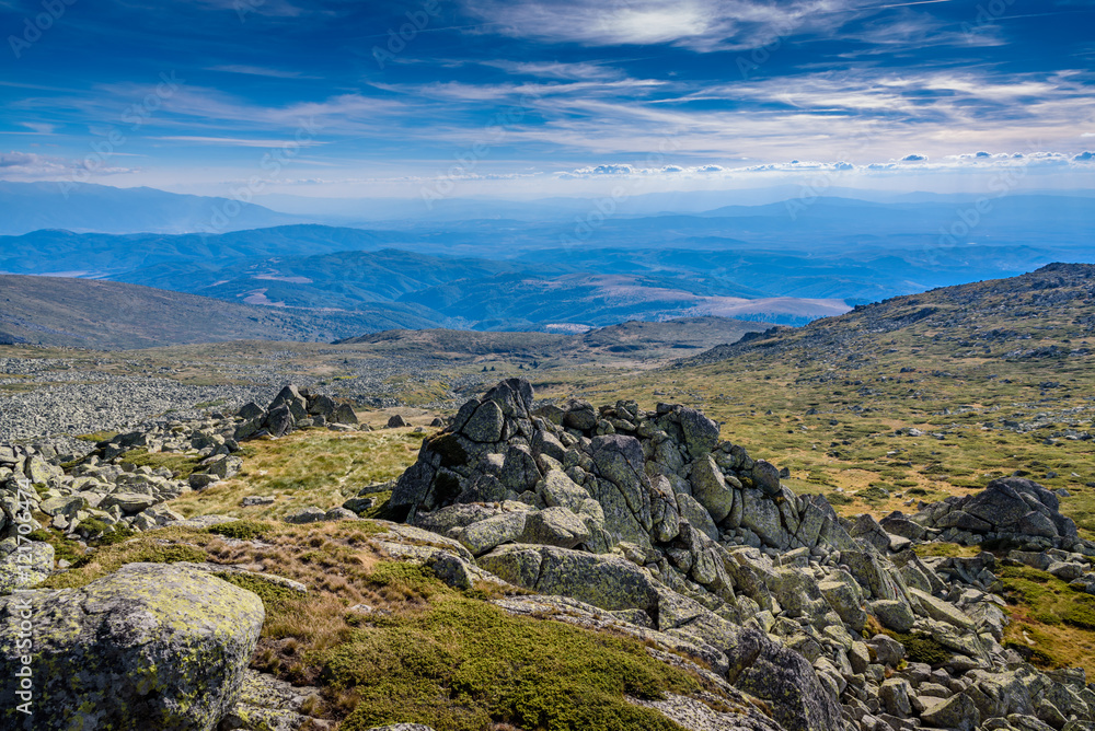 Beautiful panoramic image at Vitosha, Sofia, Bulgaria with vast view across several miles - with jagged rocks in the foreground and mountain chains in the foreground