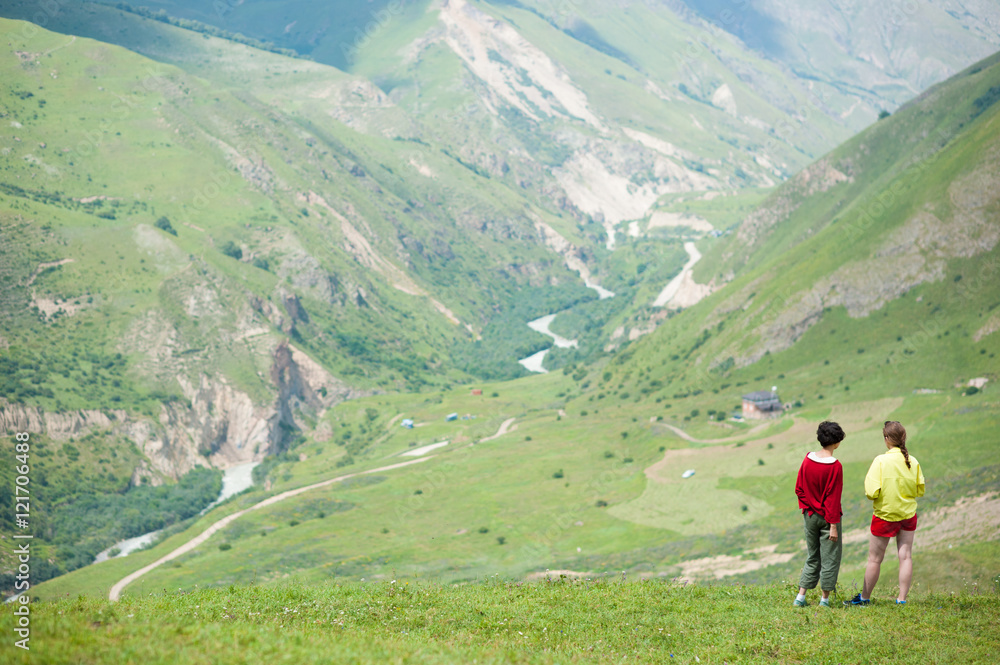 two young girls standing in the mountains