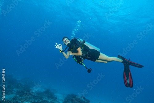 Young woman scuba diver showing ok sign