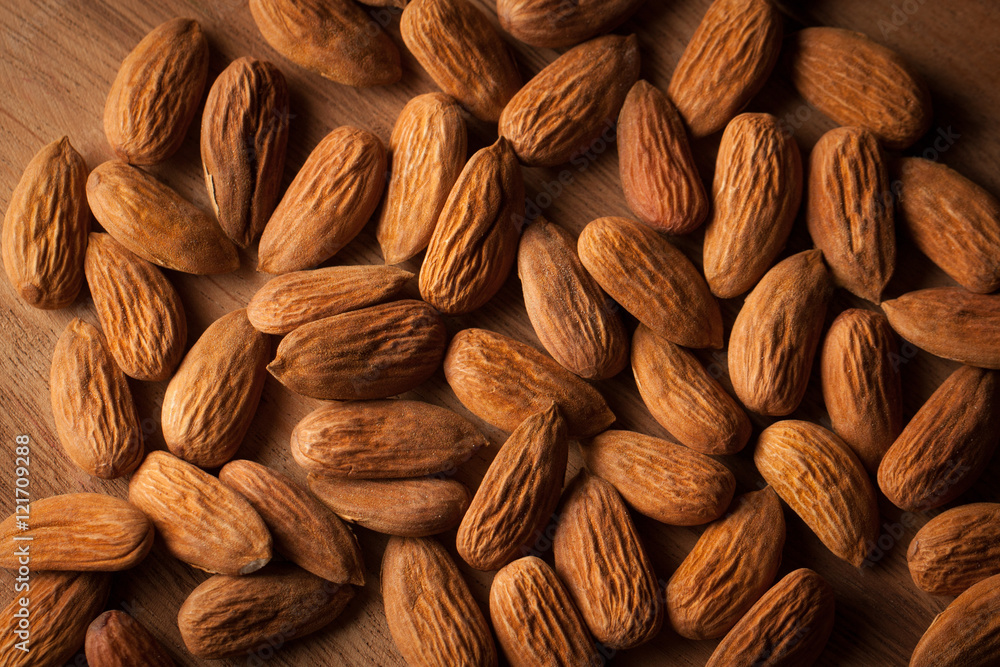 Fototapeta premium Almonds on wooden background