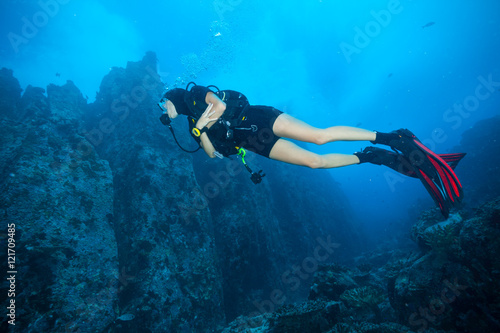 Young woman scuba diver exploring sea bottom