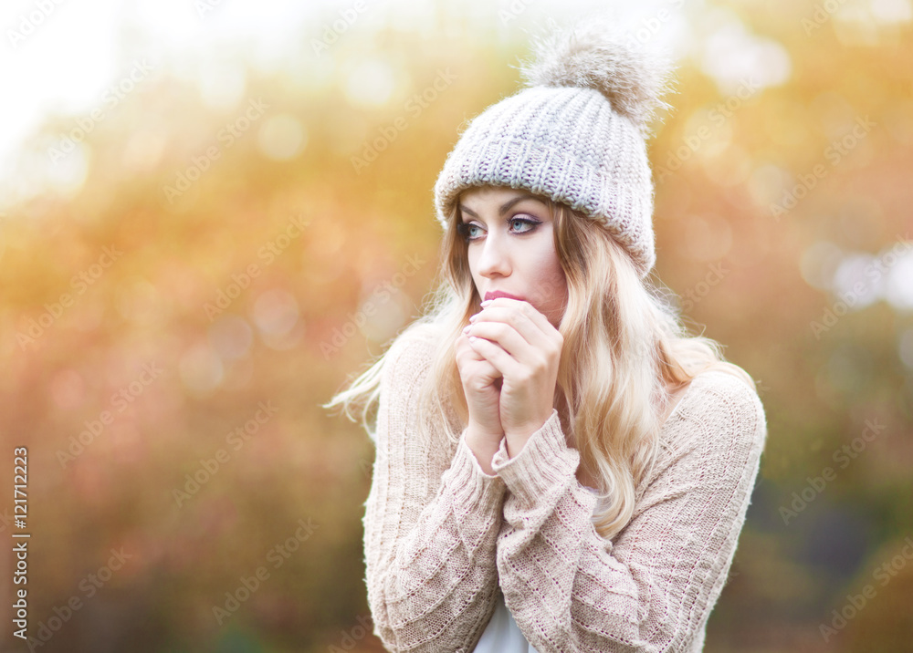 Beautiful young blonde woman wearing knitted sweater and hat. Cold fall and winter concept Beautiful young blonde woman wearing knitted sweater and hat. Cold fall and winter concept